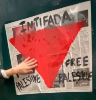 Wheatpasted poster with a downwards-facing red triangle with the words "INTIFADA" and "FREE PALESTINE" around it.